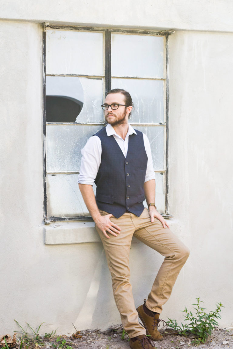 male modeling against old building with broken window