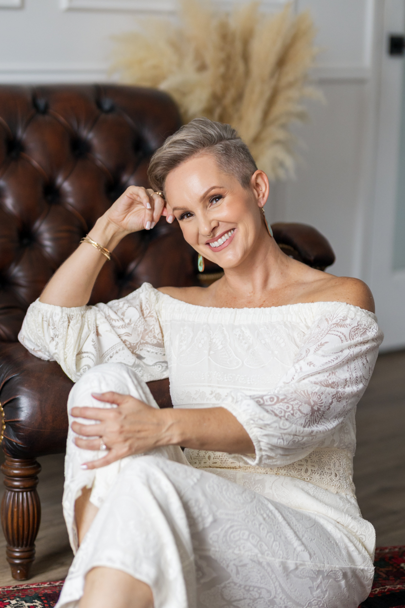 woman posing for headshots by overstuffed chair