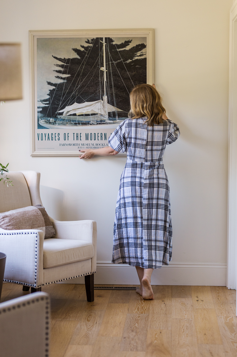 home decorator straightening a picture