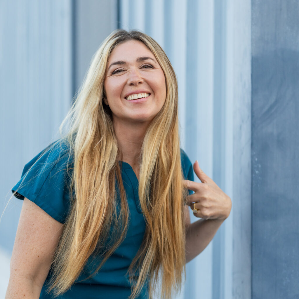 Headshot in front of blue wall at marina