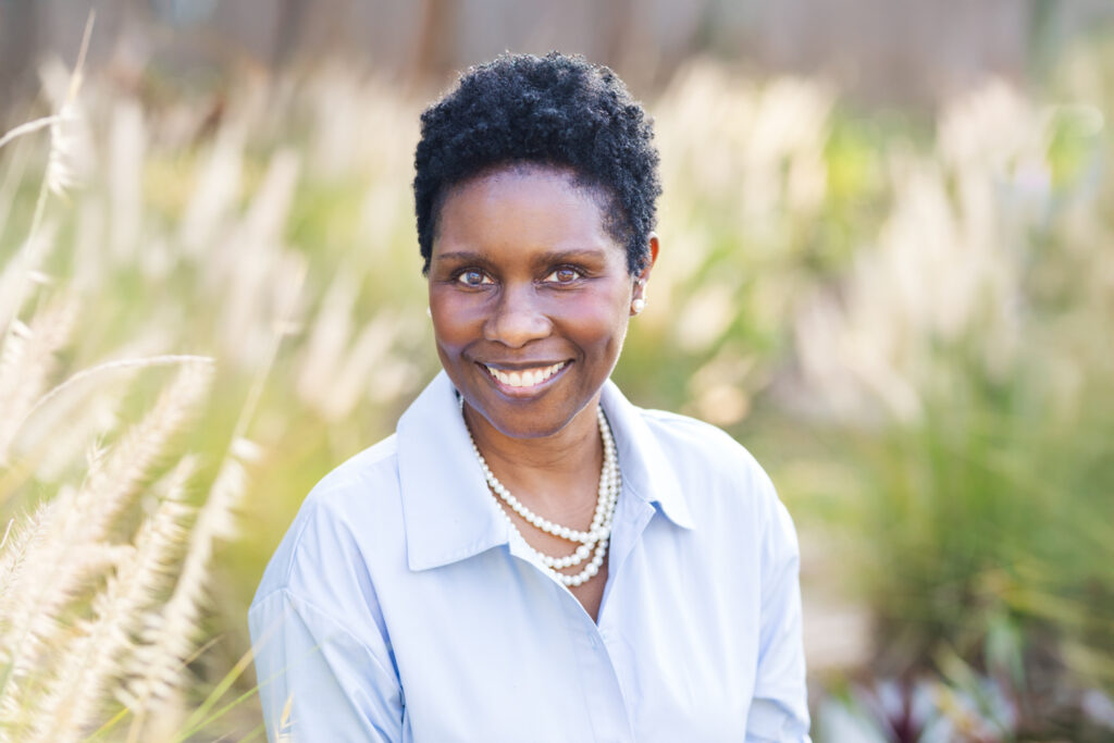 Woman posing for headshots in soft tall grass