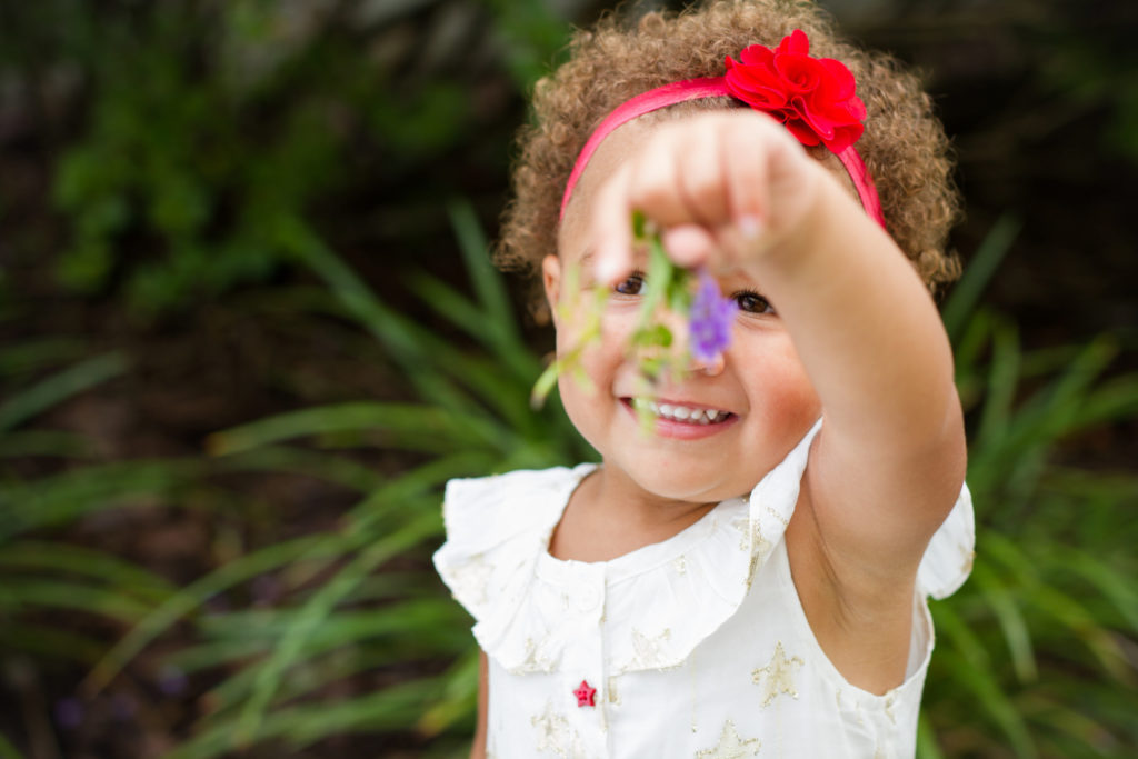 girl holding up a flower