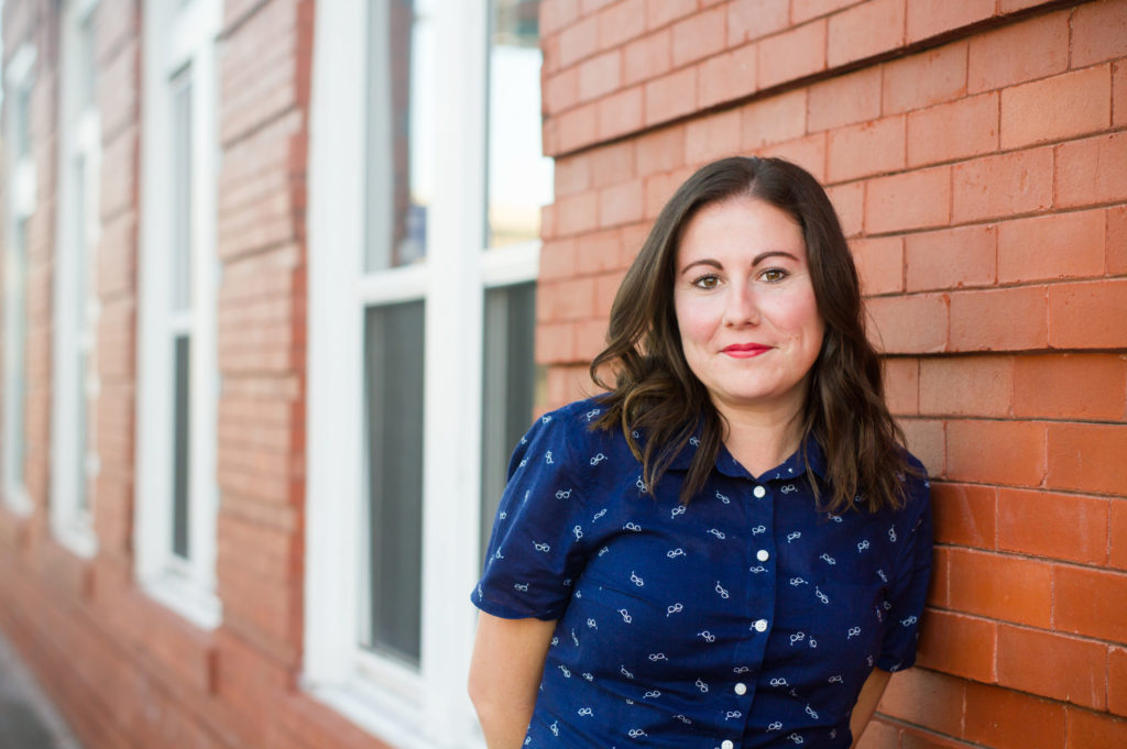 woman leaning on orange wall