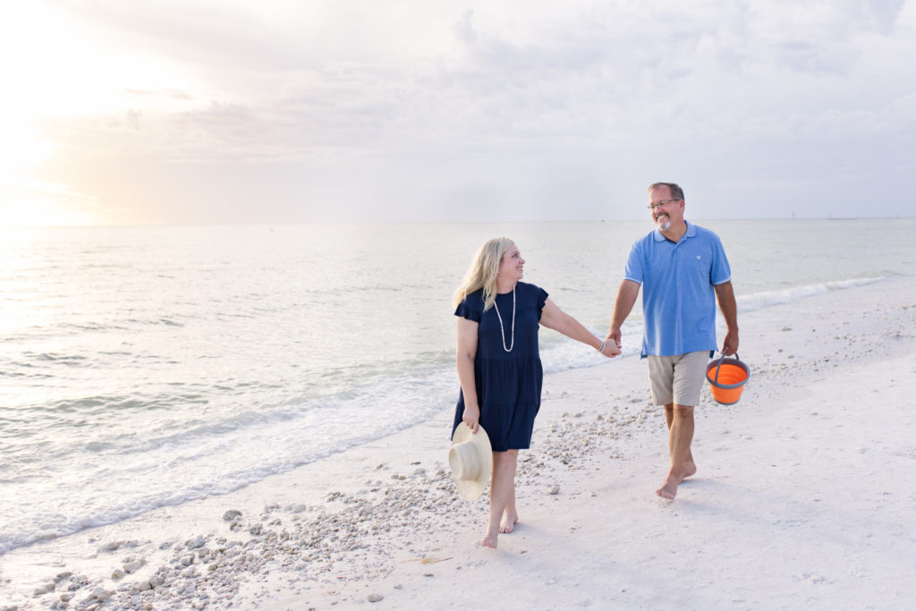 couple walking hand and hand down the beach