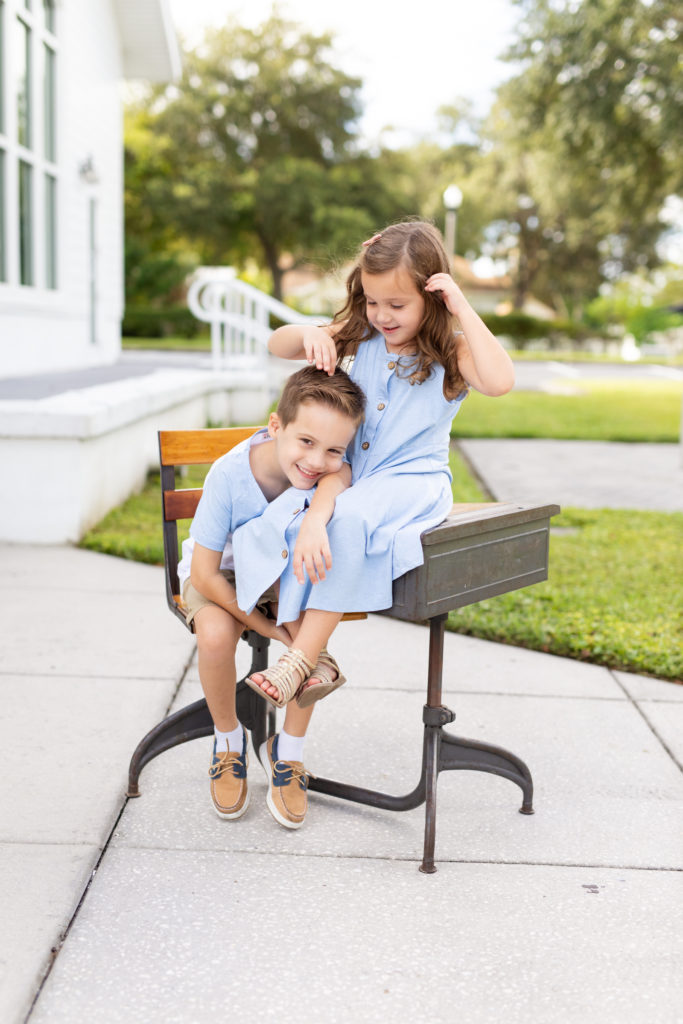 brother and sister sitting on vintage school desk