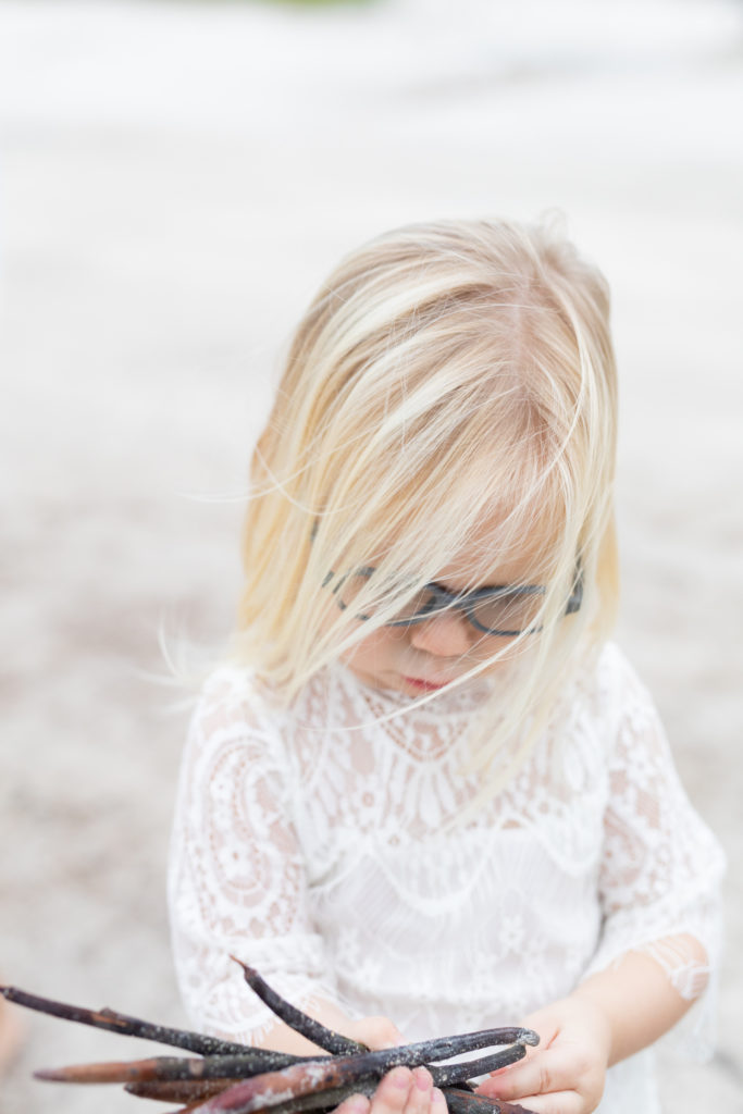 girl playing with beach sticks