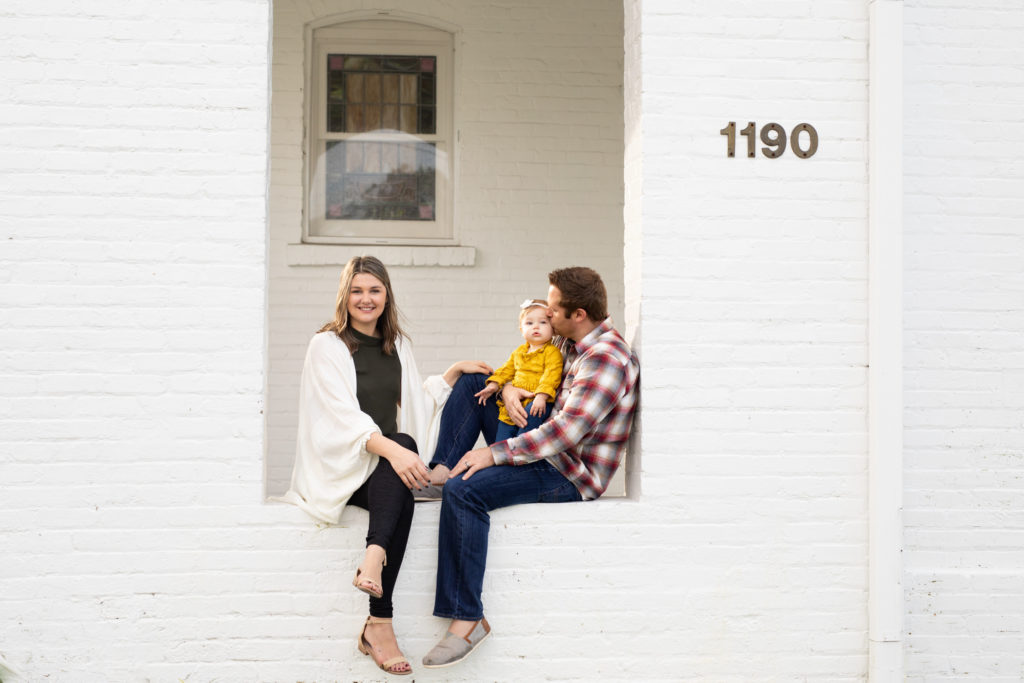 family sitting on brick ledge