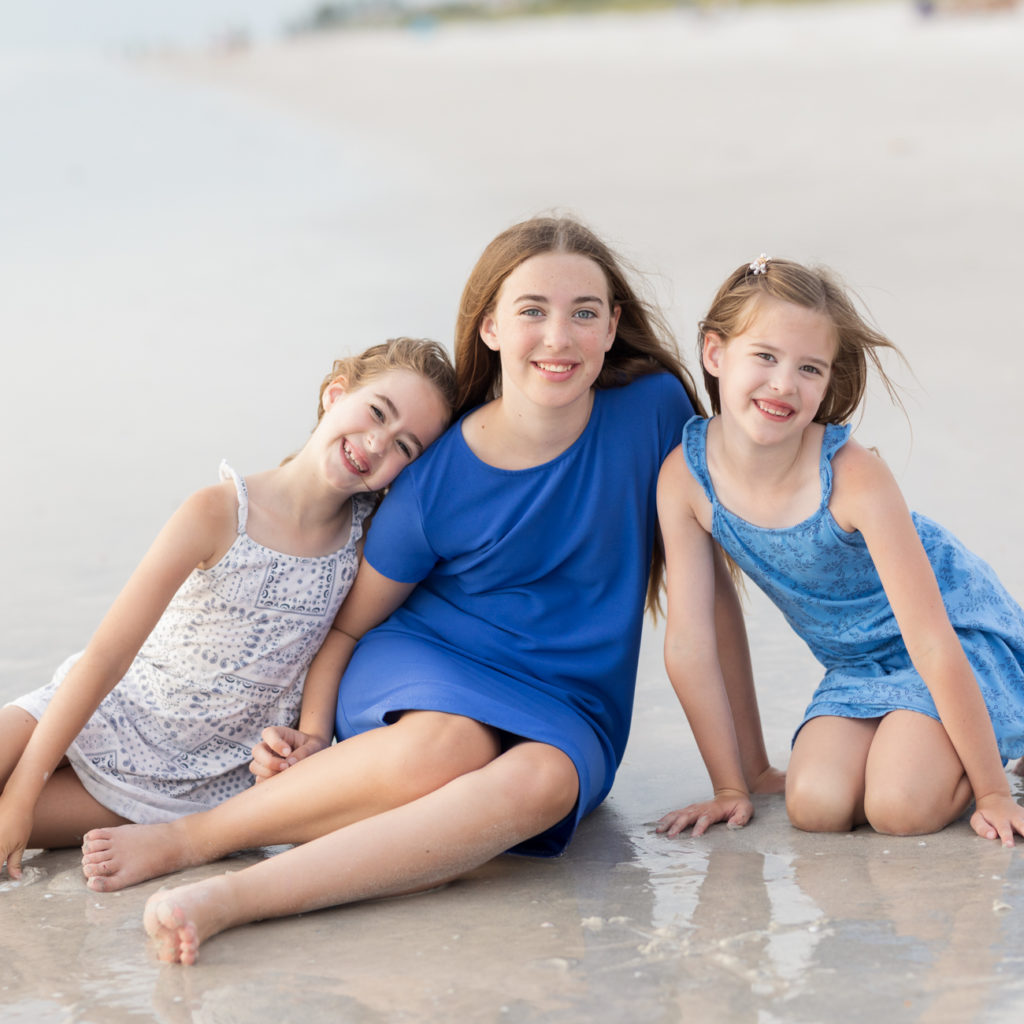 three sisters posing at the beach