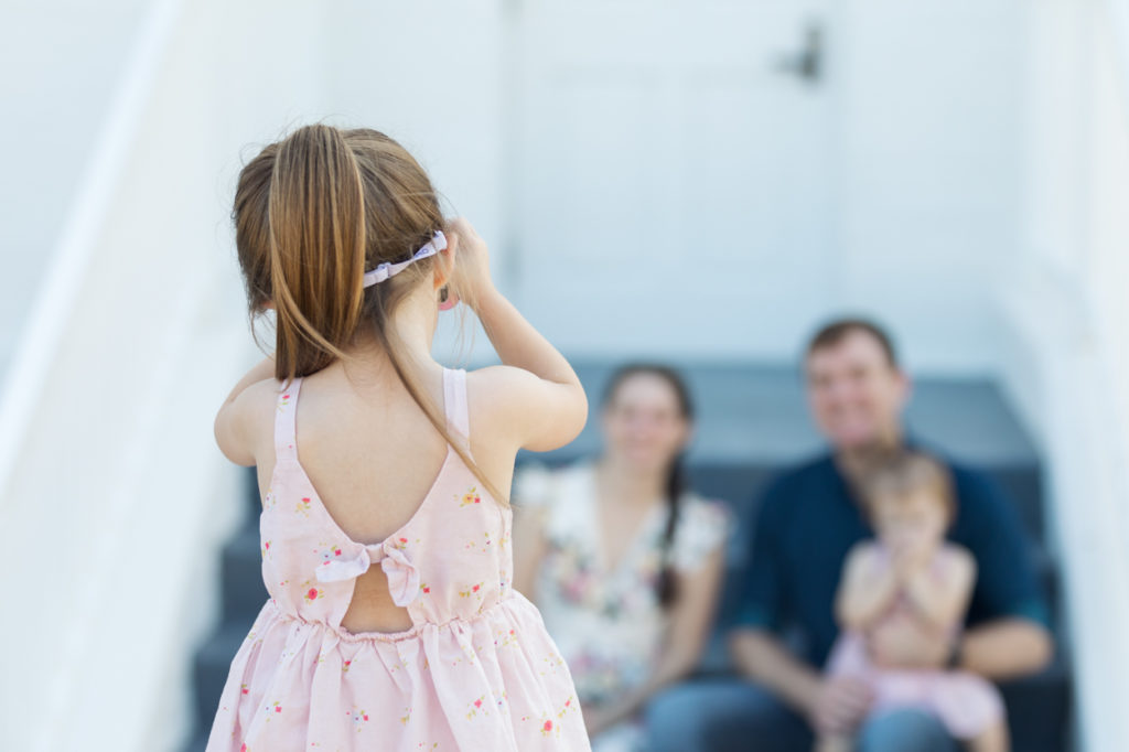 little girl taking photos of her family