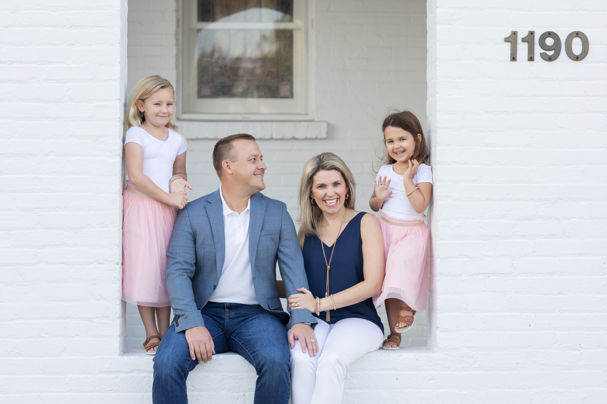family of 4 sitting on ledge together