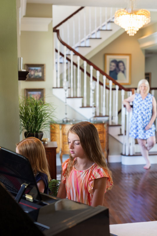 kids playing piano while grandma looks on
