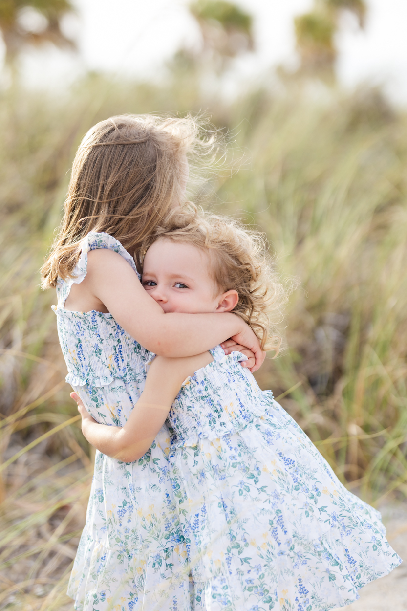 sisters hugging in beach grass