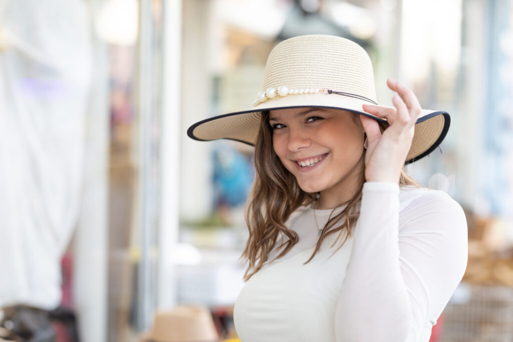girl shopping tries on a hat