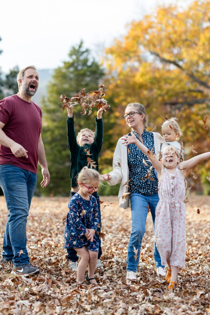 best photographer for family photos family throwing leaves
