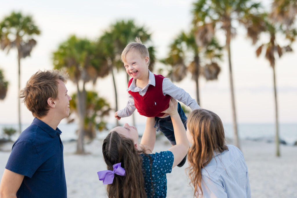 teens holding little brother in the air