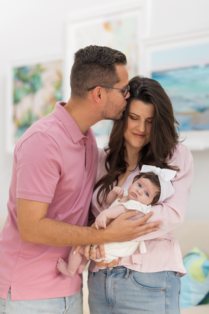 new parents holding their daughter in living room