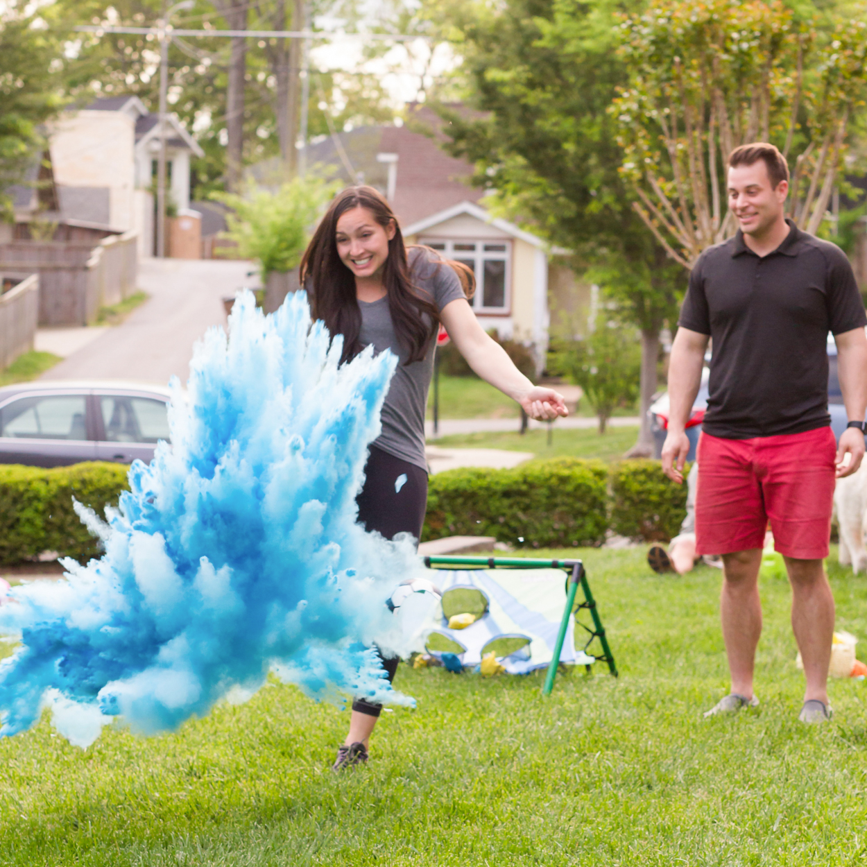 gender reveal kicking soccer ball with blue powder