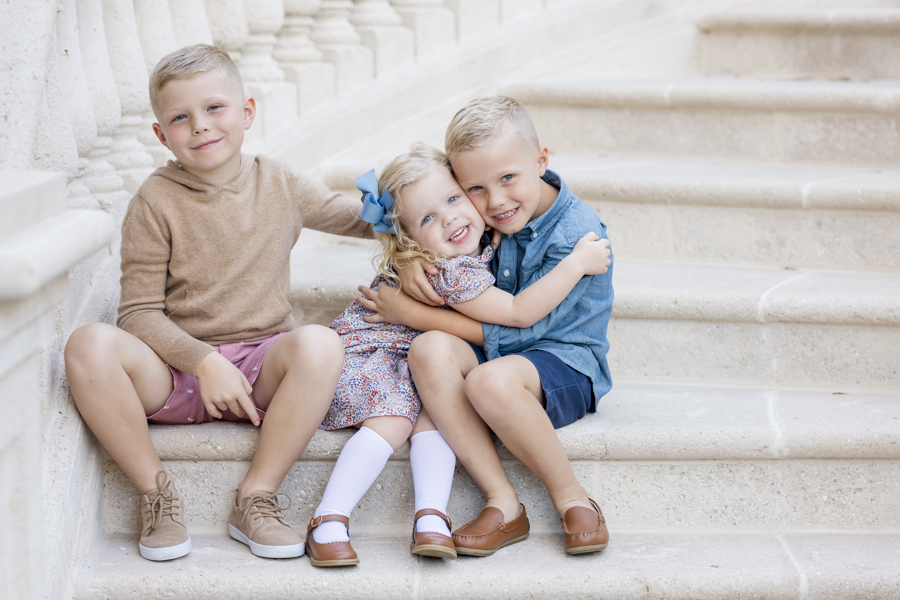 3 kids sitting on grand staircase