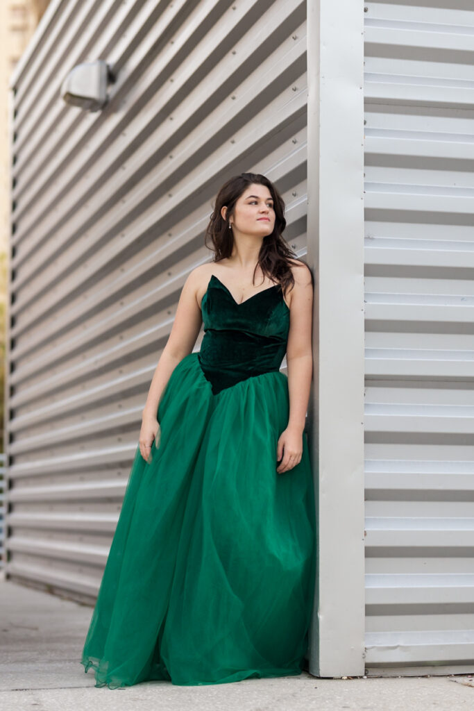 girl in gown leaning on wall