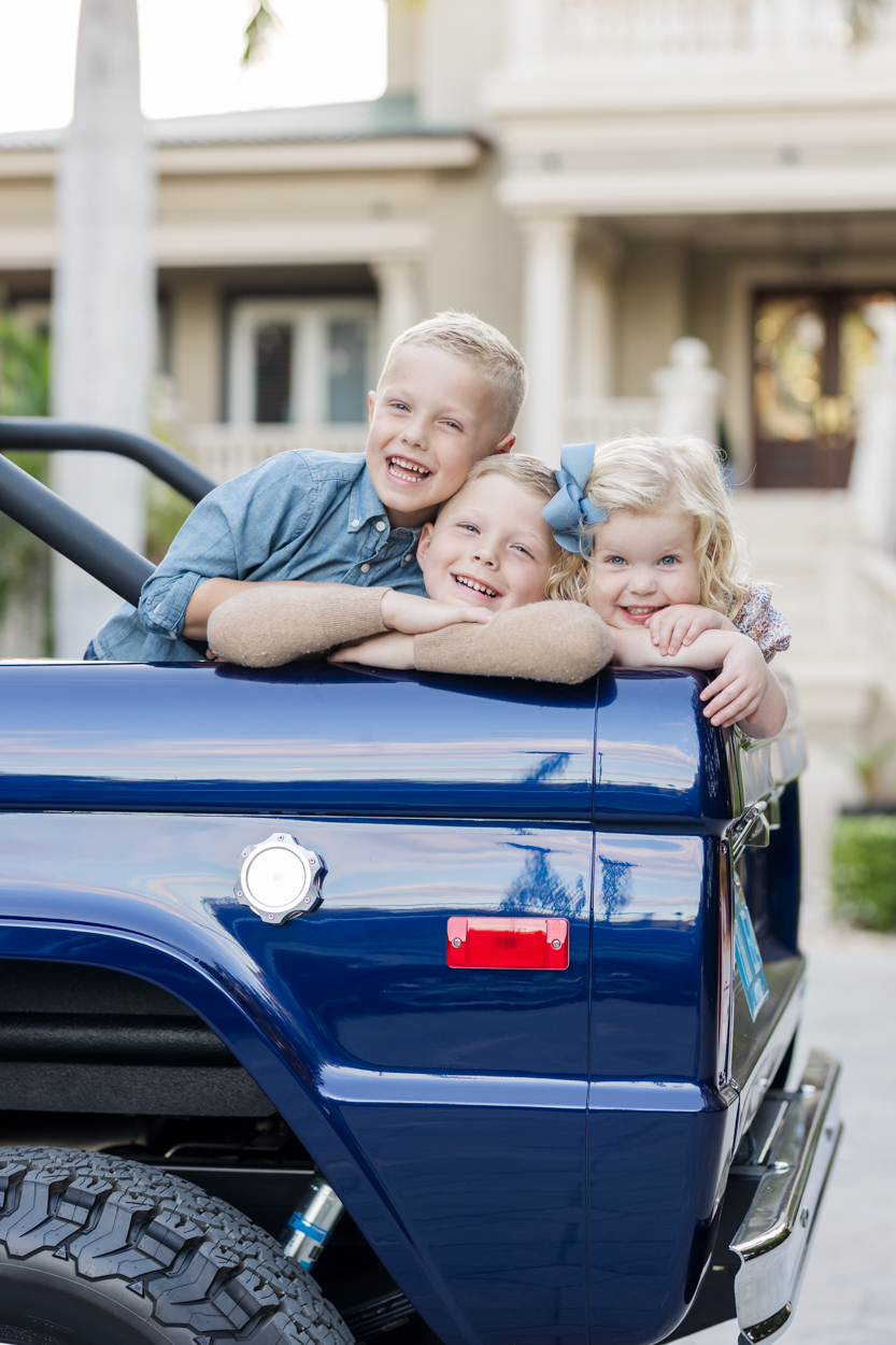 3 kids in the back of a vintage truck