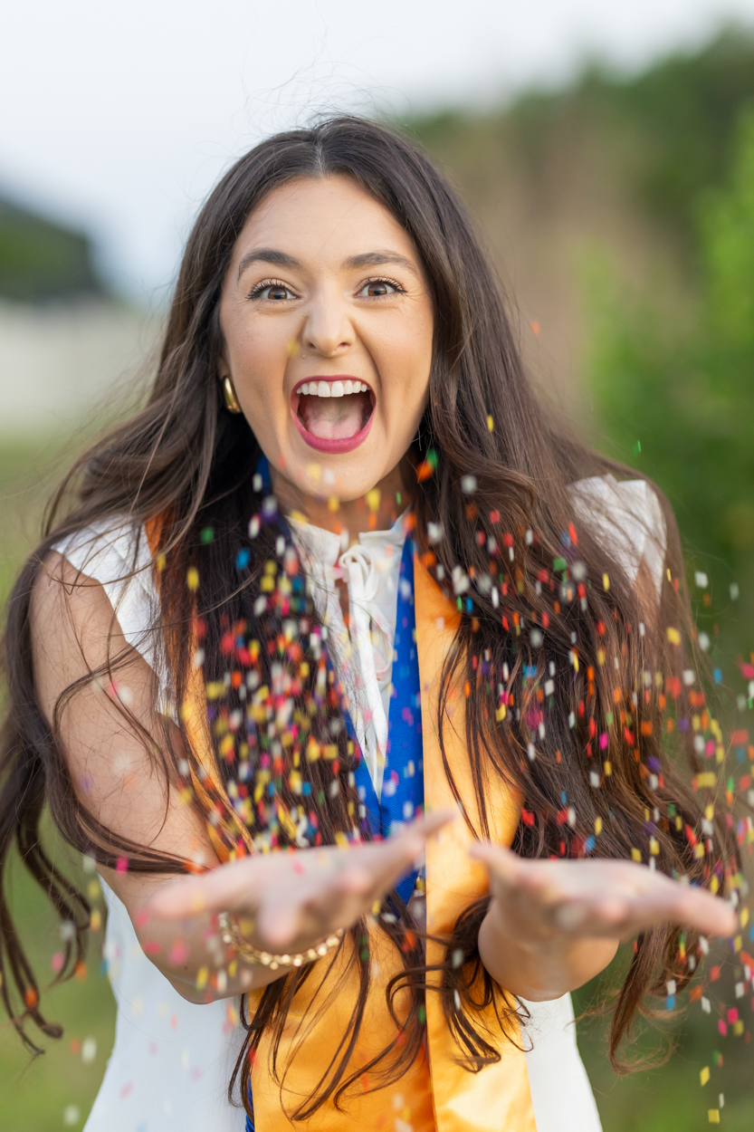college grad throwing sprinkles to celebrate