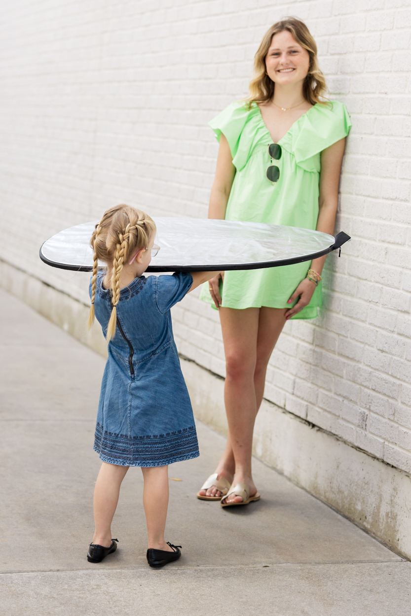 girl holding a reflector for girl taking portrait