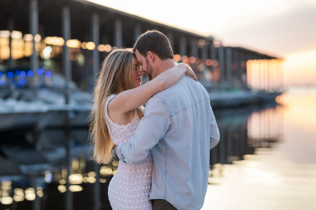 Couple embraces by the pier