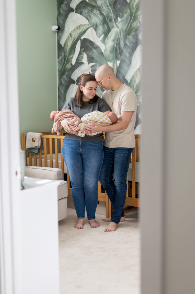 New parents holding twins in the nursing