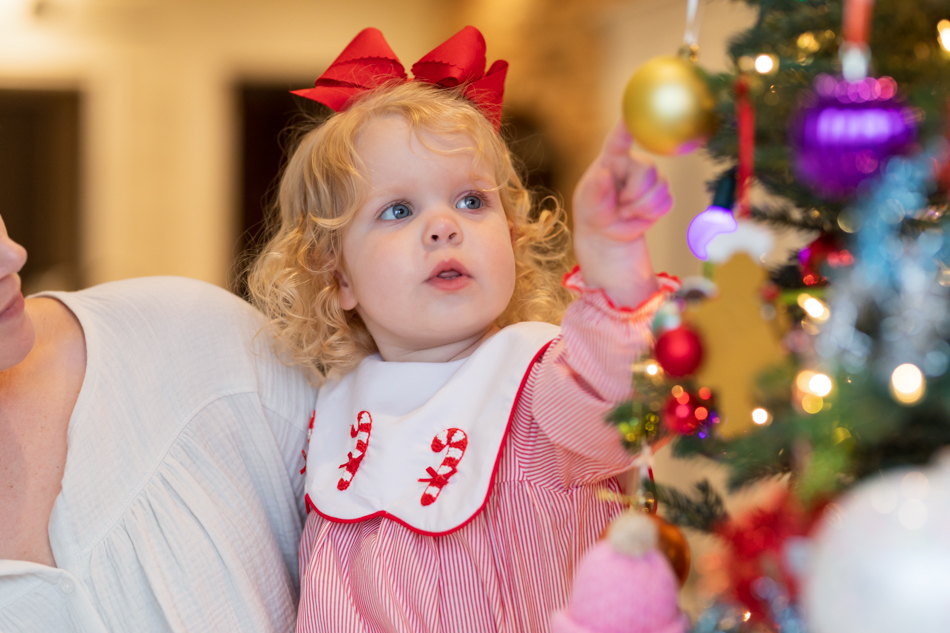 girl reaching out for christmas lights