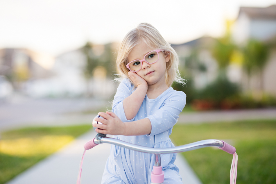 girl posing on vintage tricycle