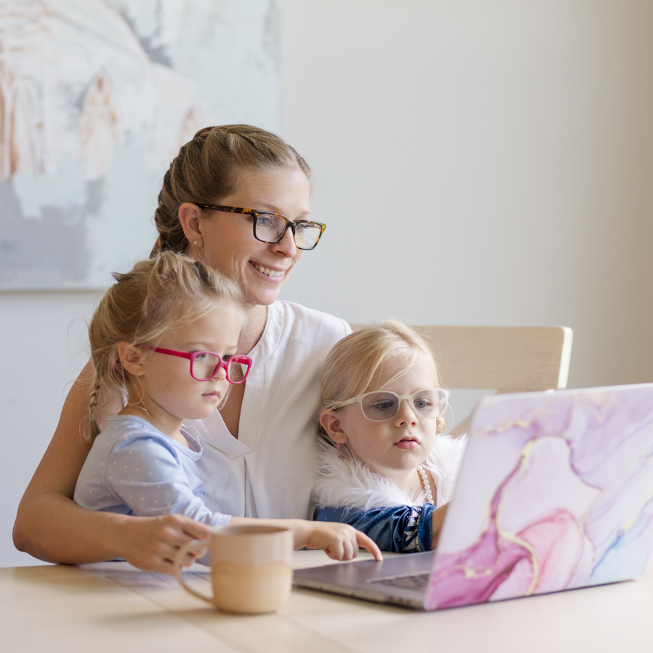 mom with two daughters at laptop