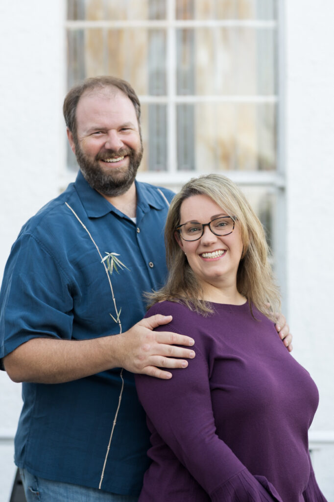 couple posing in front of stained glass
