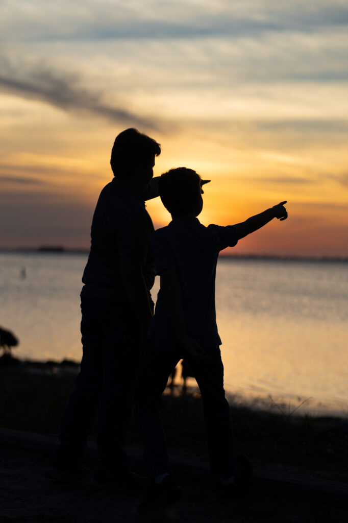 silhouette photo of boys looking at ocean