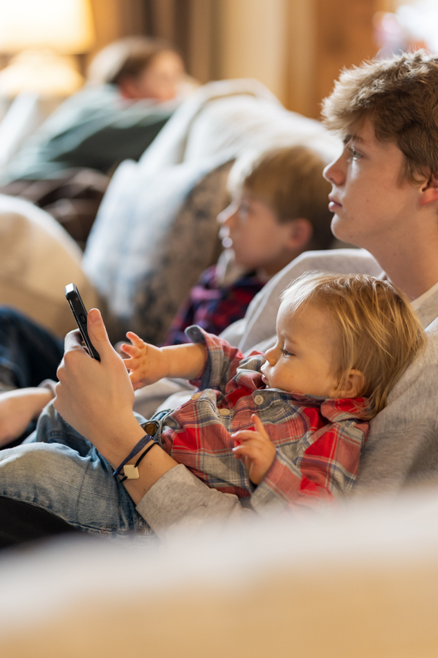 baby playing on teen's phone