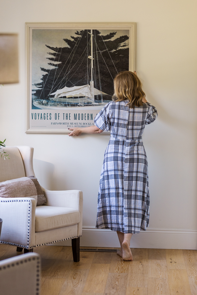interior designer straightening a wall picture