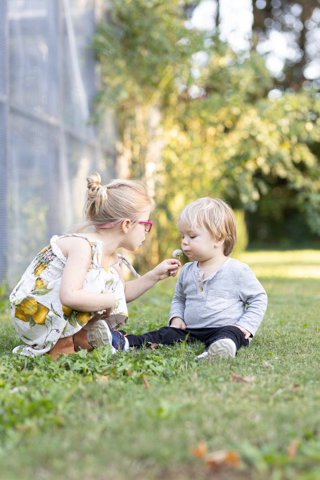 2 little kids blowing dandy lions