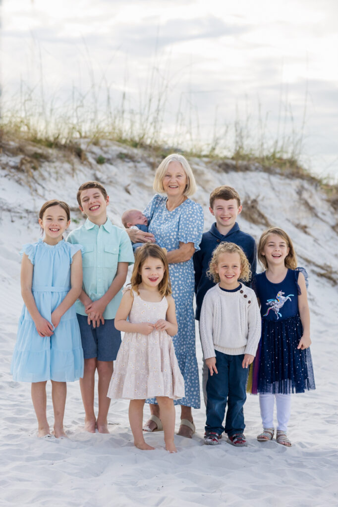 grandmother posing with her grandchildren at the beach