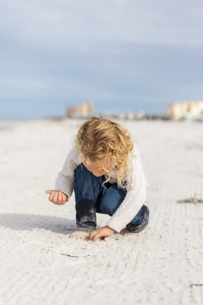 boy playing in sand at beach