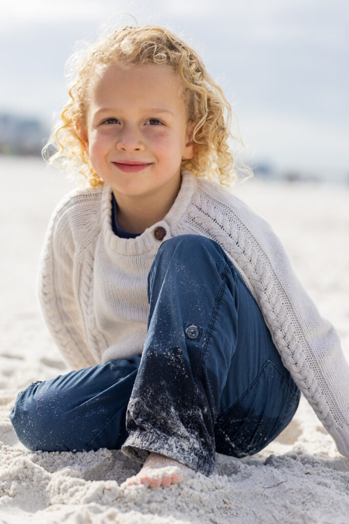 boy at beach smiling at camera