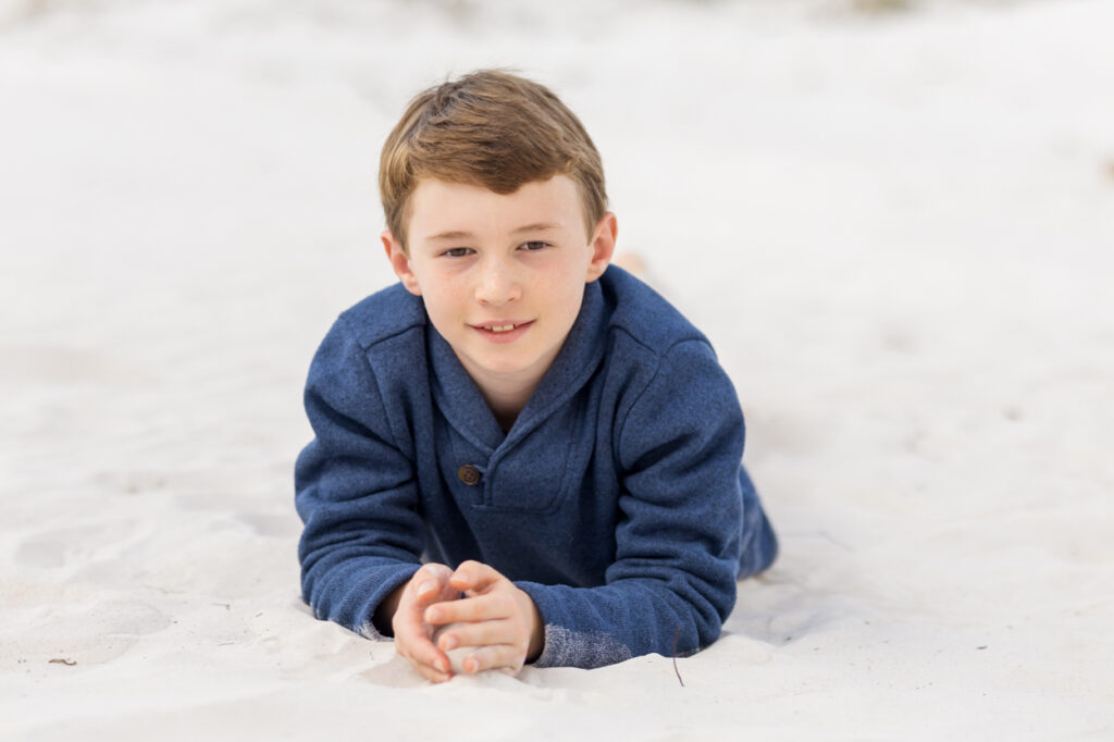 boy laying on his stomach at beach