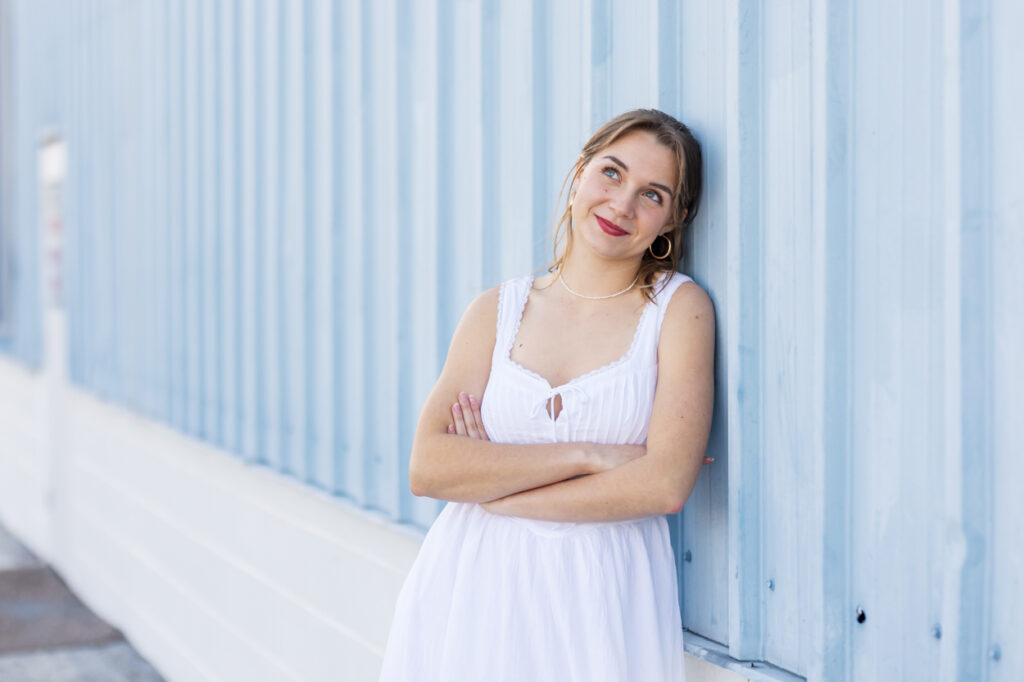 high school senior leaning against blue wall