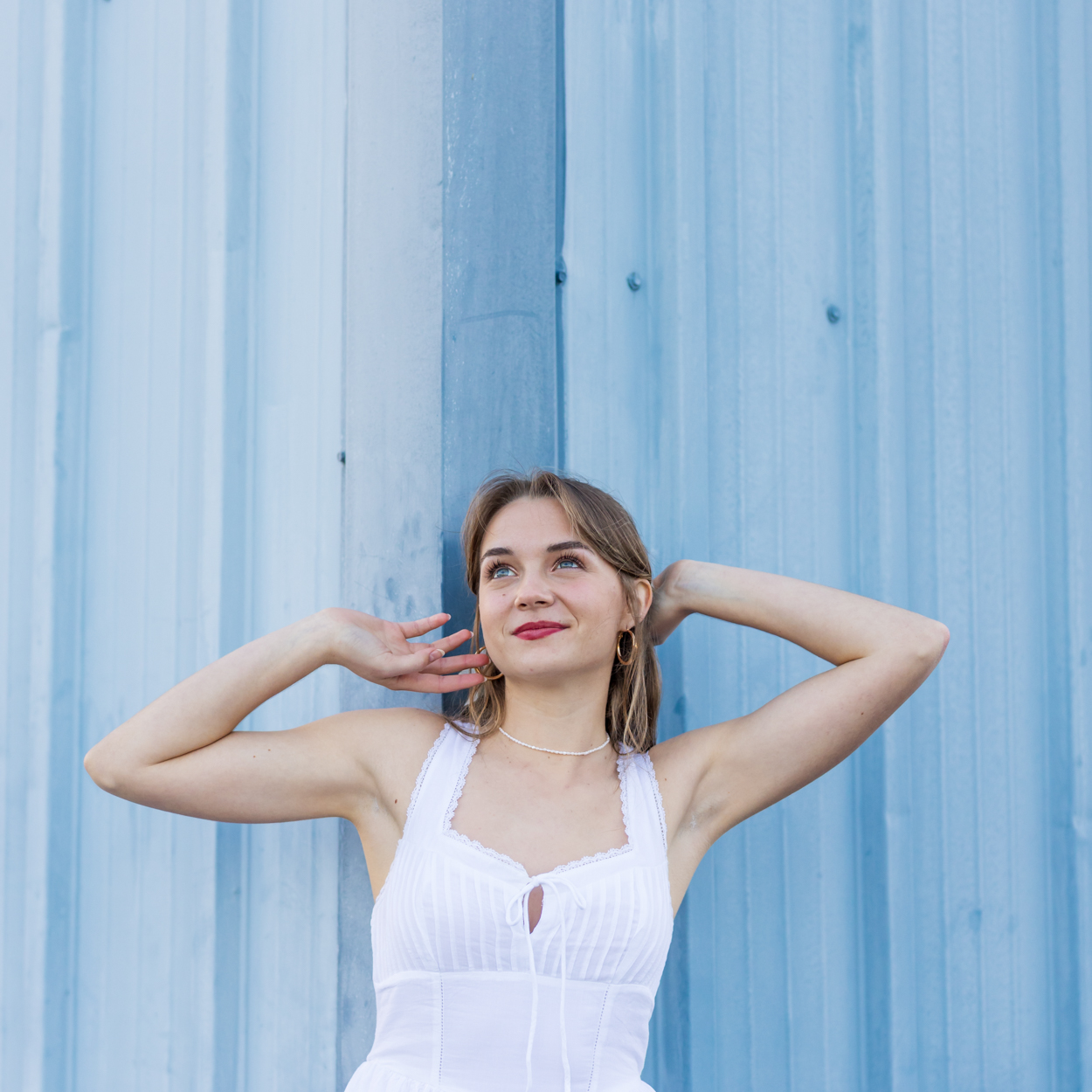 girl against blue siding