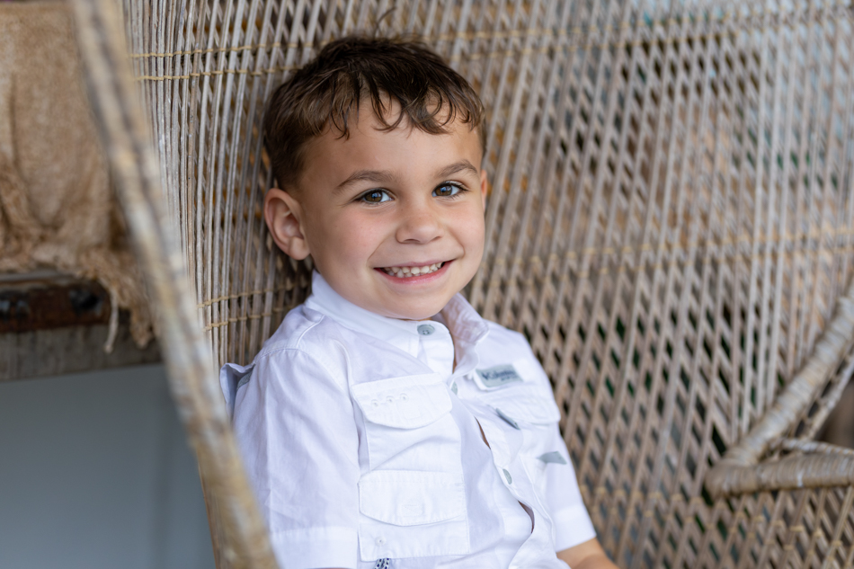 boy in wicker high back chair