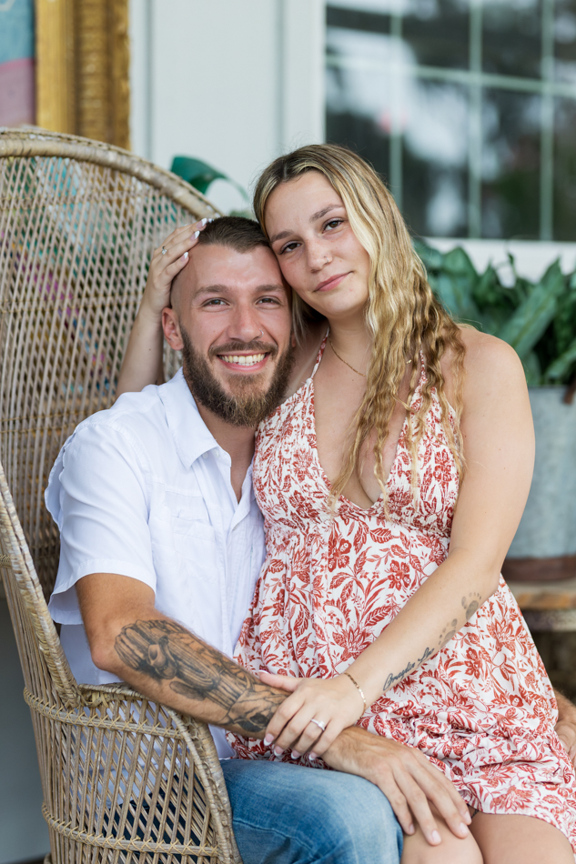 couple posing in high back wicker chair