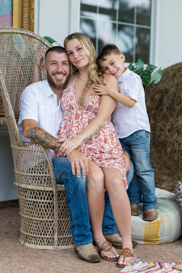 family posing in high back wicker chair