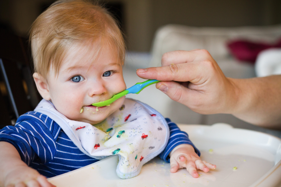 dad feeding baby in his high chair