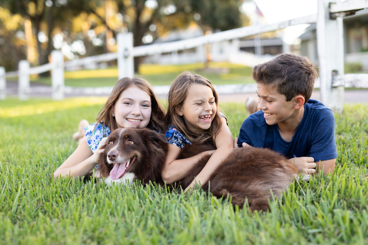 kids laying on their dog laughing