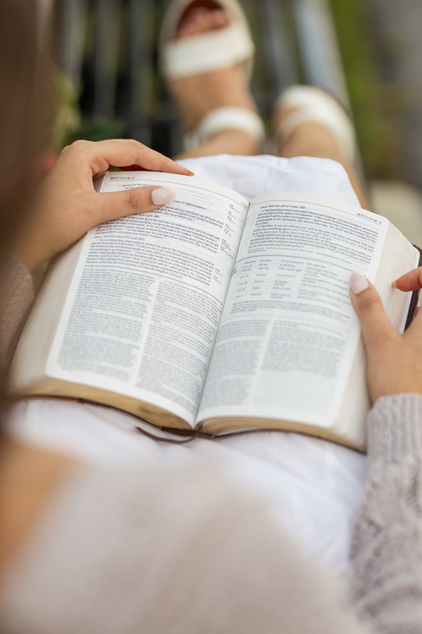 reading the bible on a bench